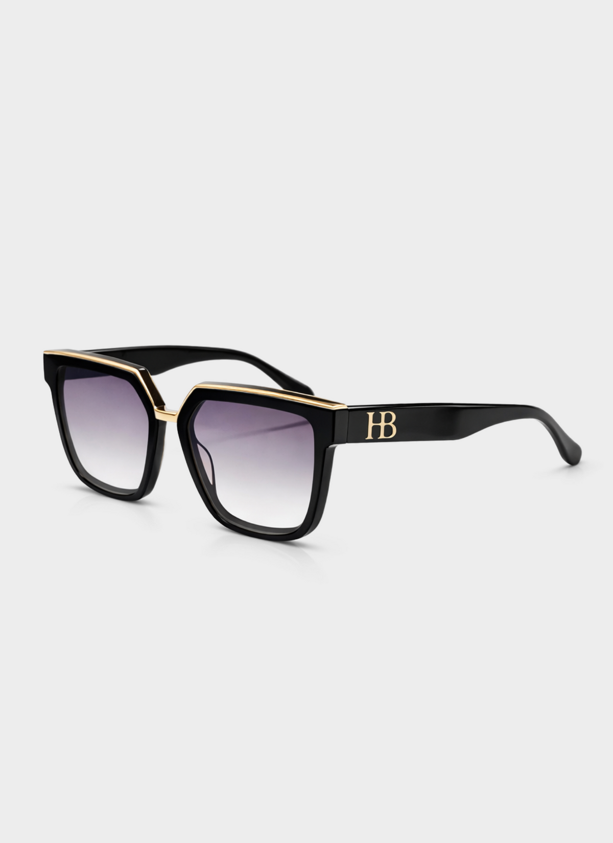Black sunglasses with gold accents on a light gray background