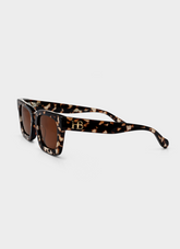 Sunglasses with tortoiseshell frame and brown lenses on a white background