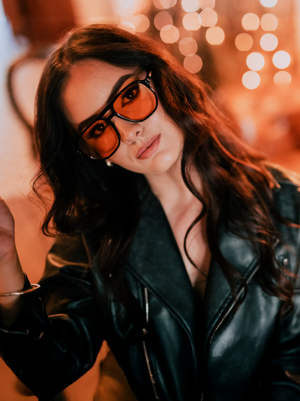 Woman wearing a black leather jacket with a blurred bokeh background